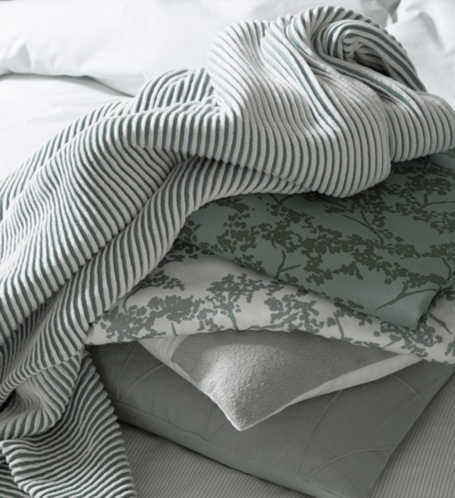 SCHÖNER WOHNEN-Kollektion Textilien für das Schlafzimmer in hellen Grüntönen mit Weiß.